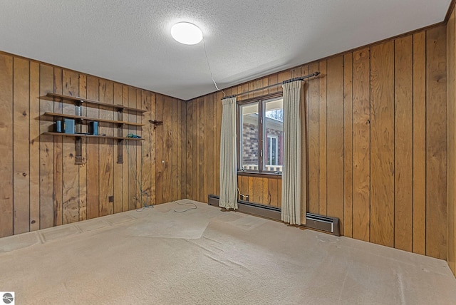 unfurnished room with wooden walls, a textured ceiling, carpet flooring, and a baseboard radiator