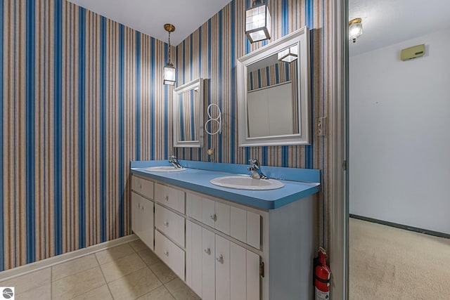 full bath featuring a sink, wallpapered walls, and baseboards