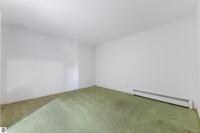 carpeted spare room featuring baseboard heating