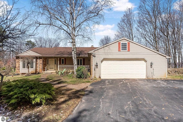 view of front facade featuring driveway, covered porch, and a garage