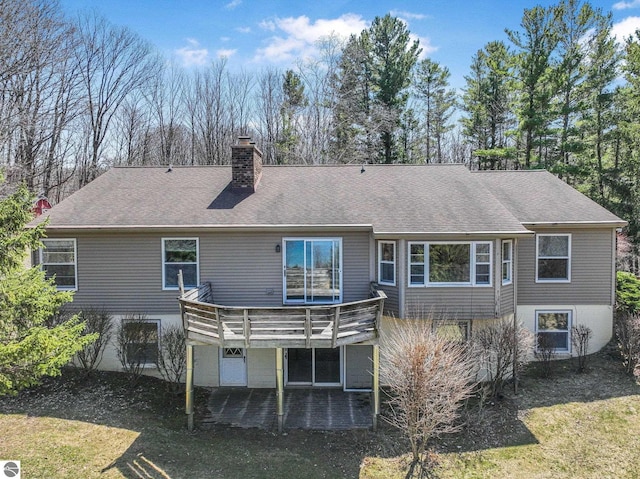 rear view of property with a chimney, a shingled roof, and a deck