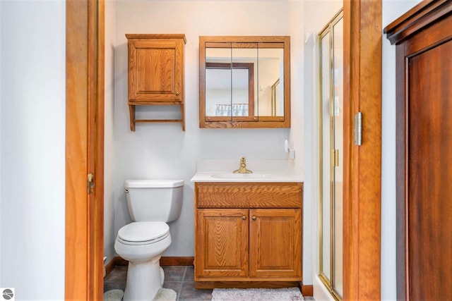 bathroom with tile patterned floors, vanity, toilet, and a stall shower