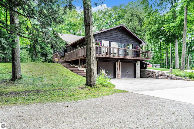 view of side of home featuring stairway, concrete driveway, a wooden deck, and a garage