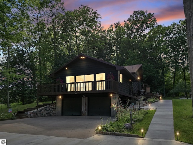 view of front of property with driveway, a deck, stairs, and a garage