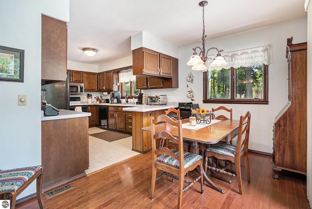 dining area with visible vents, a chandelier, and light wood-style floors