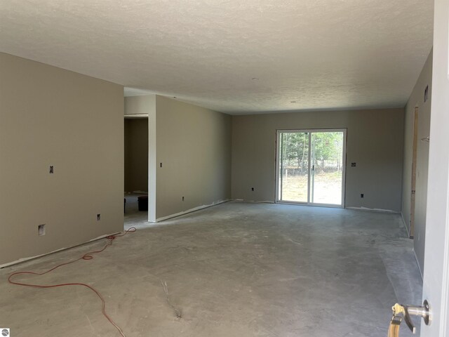 2740 Mockingbird Dr Unit 19, Traverse City, MI 49685 - unfurnished room featuring concrete floors and a textured ceiling