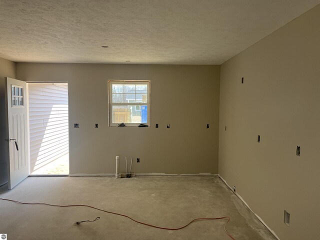 2740 Mockingbird Dr Unit 19, Traverse City, MI 49685 - spare room with concrete floors, a textured ceiling, and baseboards