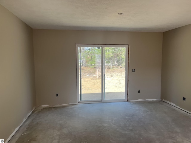 2740 Mockingbird Dr Unit 19, Traverse City, MI 49685 - spare room with unfinished concrete floors and baseboards
