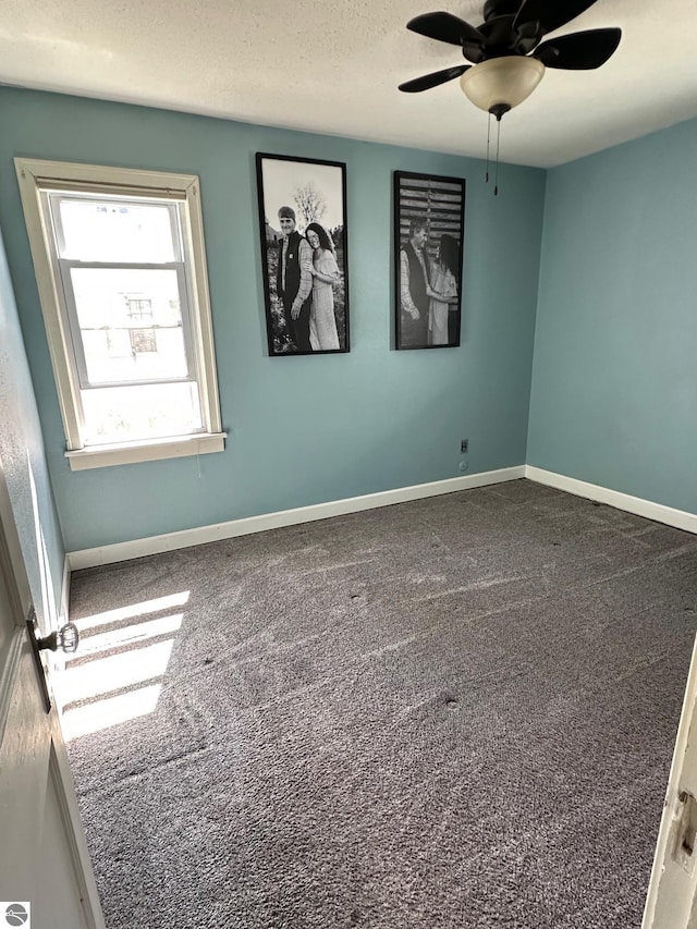 spare room with baseboards, ceiling fan, a textured ceiling, and carpet flooring