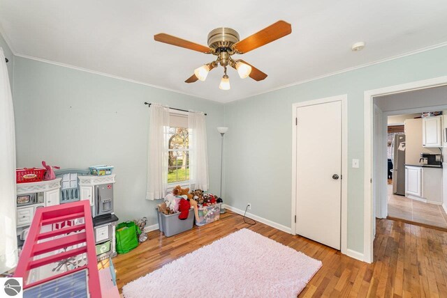 1016 Argyle Ct, Alma, MI 48801 - recreation room featuring crown molding, a ceiling fan, light wood-style flooring, and baseboards