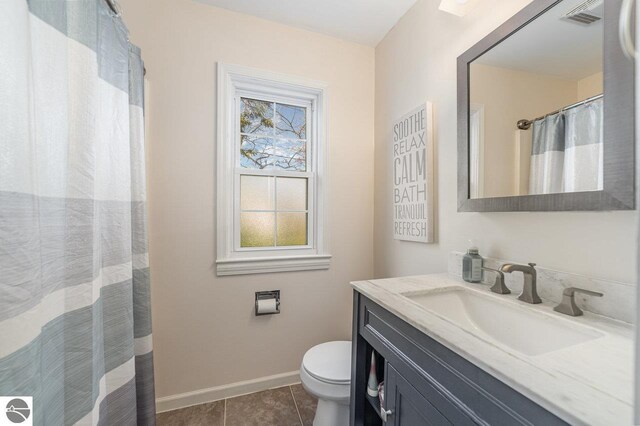 1016 Argyle Ct, Alma, MI 48801 - bathroom with visible vents, baseboards, toilet, vanity, and tile patterned flooring