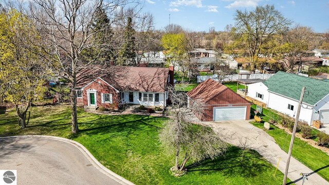 1016 Argyle Ct, Alma, MI 48801 - ranch-style home featuring a residential view, concrete driveway, a garage, and a front lawn