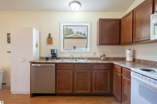 3193 Crimson Ranch Ln, Traverse City, MI 49685 - kitchen with electric stove, a sink, light wood-style floors, dark countertops, and dishwasher