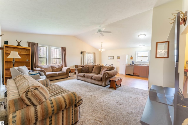 3193 Crimson Ranch Ln, Traverse City, MI 49685 - living area featuring vaulted ceiling, light carpet, and ceiling fan with notable chandelier