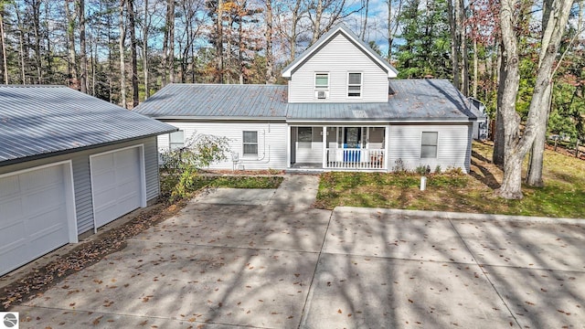 6836 NW Aarwood Trl, Rapid City, MI 49676 - traditional home featuring a detached garage, an outdoor structure, a porch, and metal roof