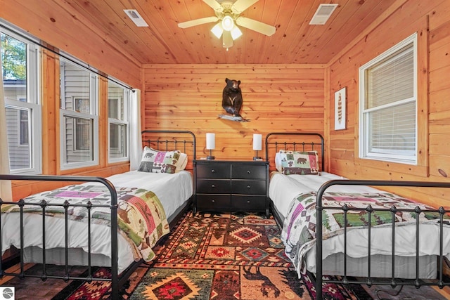 6836 NW Aarwood Trl, Rapid City, MI 49676 - bedroom featuring visible vents, wood walls, ceiling fan, and wooden ceiling