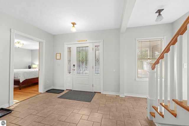 6836 NW Aarwood Trl, Rapid City, MI 49676 - entrance foyer featuring baseboards, stone finish flooring, and stairway