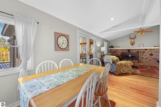 6836 NW Aarwood Trl, Rapid City, MI 49676 - dining room featuring ceiling fan, a wood stove, light wood-style floors, recessed lighting, and vaulted ceiling