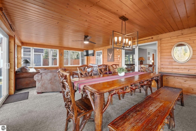 6836 NW Aarwood Trl, Rapid City, MI 49676 - carpeted dining room with wooden walls, a chandelier, and wooden ceiling