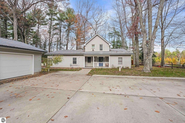 6836 NW Aarwood Trl, Rapid City, MI 49676 - traditional-style house featuring fence, covered porch, and metal roof