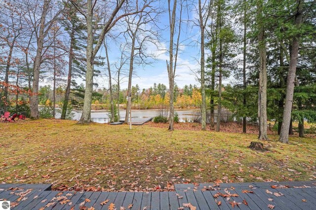 6836 NW Aarwood Trl, Rapid City, MI 49676 - view of yard featuring a deck with water view