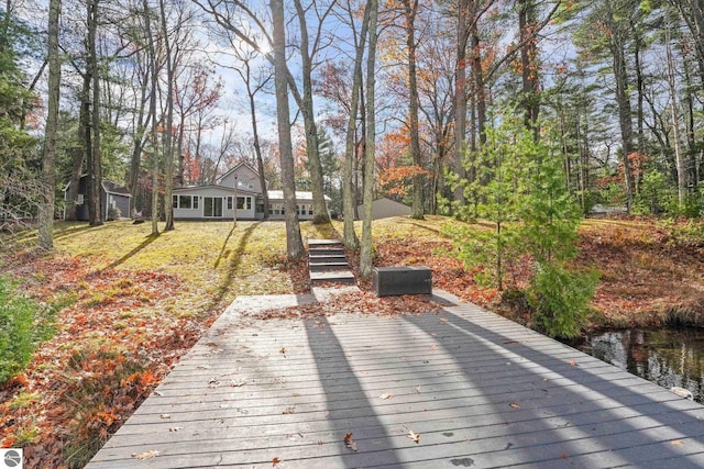 6836 NW Aarwood Trl, Rapid City, MI 49676 - wooden terrace featuring a yard