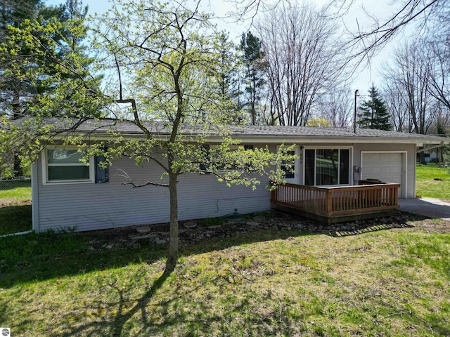 view of front of property with an attached garage, a front yard, and a deck