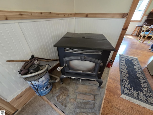 4280 Birch St, Lake, MI 48632 - detailed view of wood finished floors, a wood stove, and wainscoting