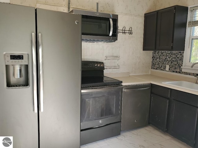 429 S Arnold, Mount Pleasant, MI 48858 - kitchen with a sink, appliances with stainless steel finishes, decorative backsplash, and marble finish floor