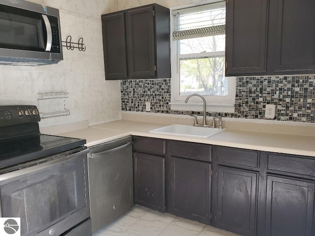 429 S Arnold, Mount Pleasant, MI 48858 - kitchen with backsplash, appliances with stainless steel finishes, a sink, light countertops, and marble finish floor