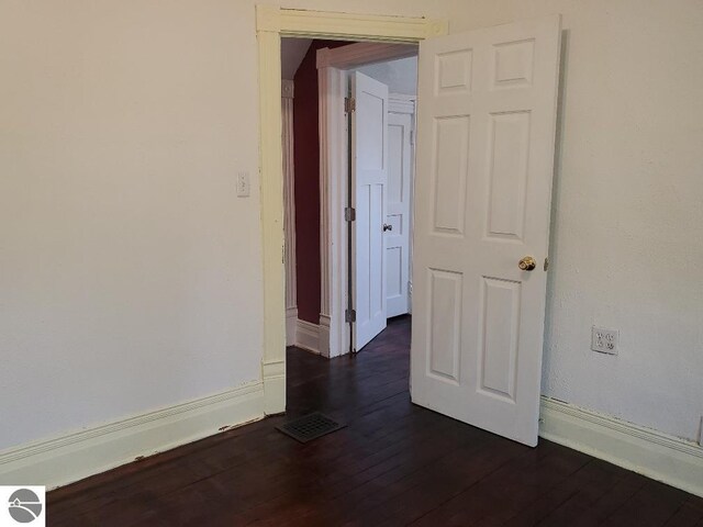 429 S Arnold, Mount Pleasant, MI 48858 - spare room featuring baseboards, dark wood-style flooring, and visible vents