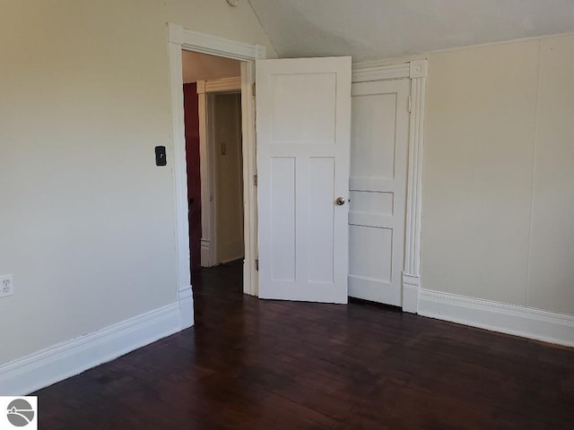 429 S Arnold, Mount Pleasant, MI 48858 - unfurnished bedroom with baseboards, lofted ceiling, and dark wood-type flooring