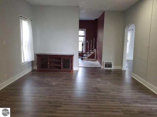 429 S Arnold, Mount Pleasant, MI 48858 - unfurnished living room with visible vents, arched walkways, a wealth of natural light, and stairway