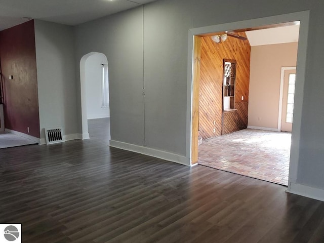 429 S Arnold, Mount Pleasant, MI 48858 - unfurnished living room featuring ceiling fan, visible vents, arched walkways, baseboards, and dark wood-style floors