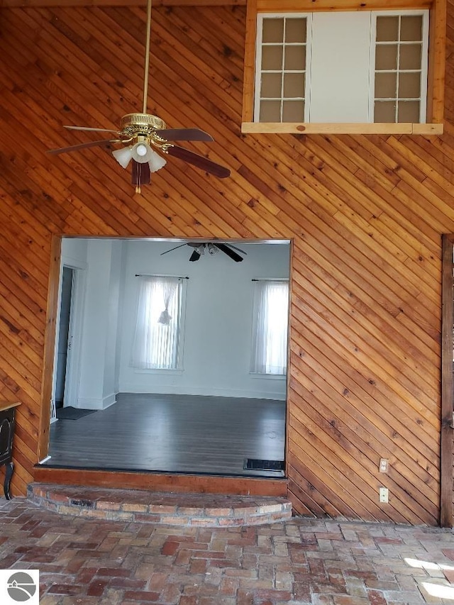 429 S Arnold, Mount Pleasant, MI 48858 - interior space featuring wooden walls, a ceiling fan, and brick floor