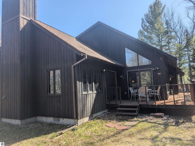 back of property featuring outdoor dining area and a wooden deck