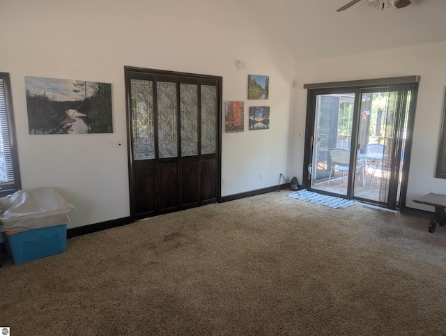 carpeted foyer featuring vaulted ceiling, baseboards, and a ceiling fan