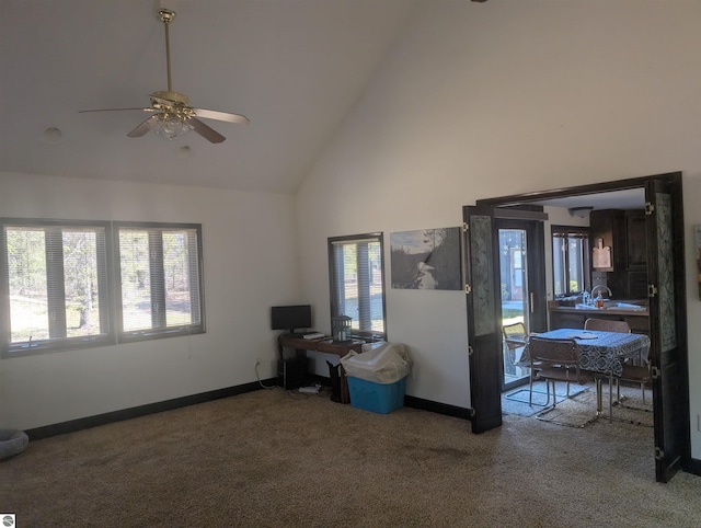 carpeted living area with high vaulted ceiling, ceiling fan, and baseboards