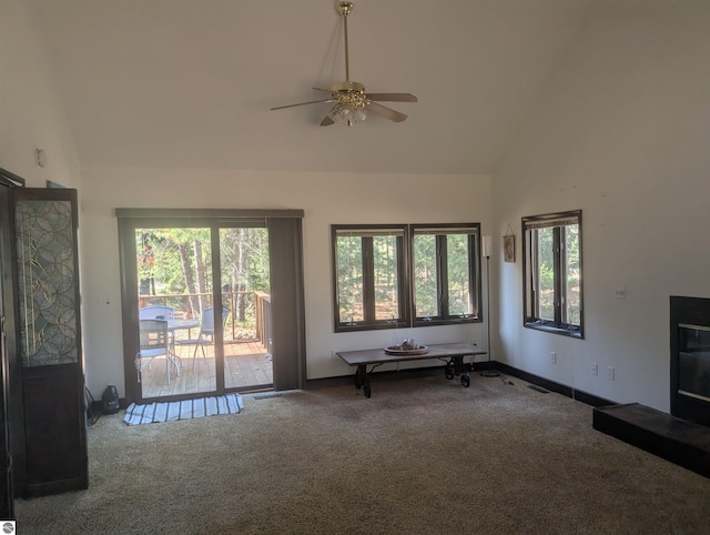living area featuring carpet floors, high vaulted ceiling, and a wealth of natural light