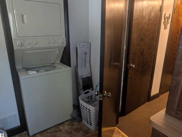 laundry area with visible vents, carpet flooring, stacked washer / drying machine, and laundry area