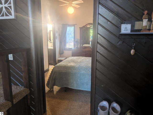 carpeted bedroom with wood walls
