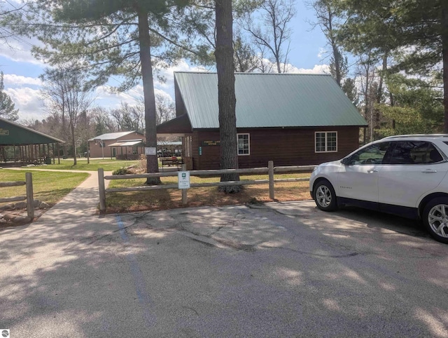 view of side of home with fence and metal roof