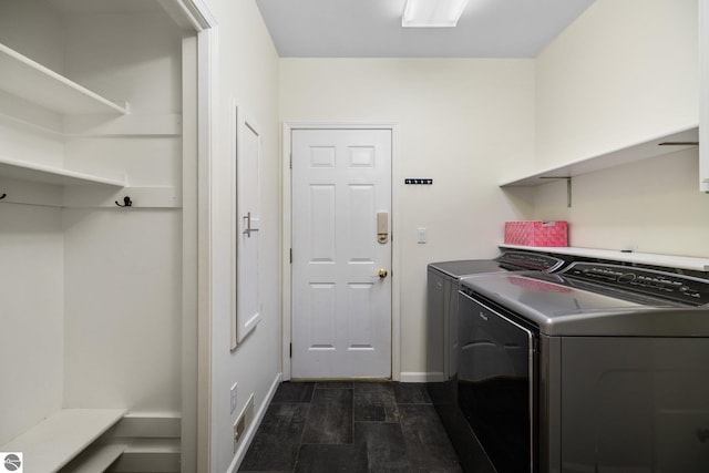 laundry area with separate washer and dryer, baseboards, laundry area, and dark wood finished floors
