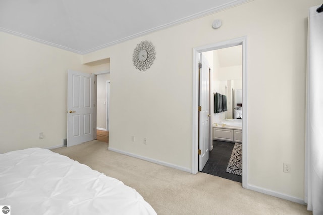 carpeted bedroom with baseboards, ornamental molding, and ensuite bath