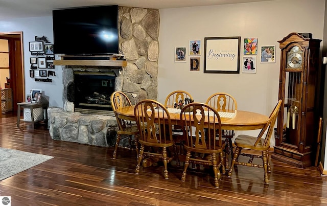 dining area with wood finished floors and a fireplace