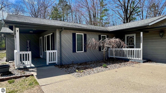 view of front of home featuring roof with shingles and covered porch