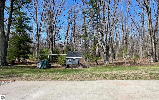 view of yard featuring a playground, a storage unit, and an outdoor structure