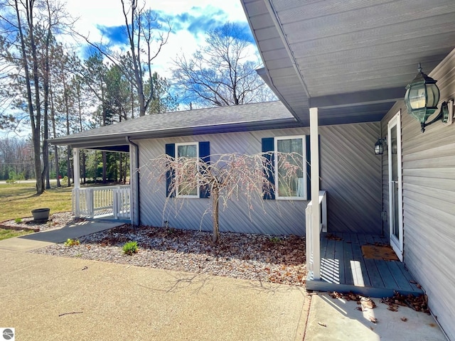 view of side of home with a shingled roof