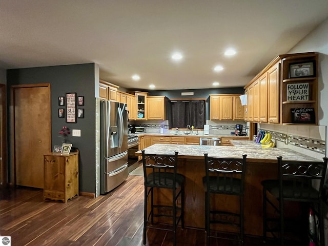 kitchen featuring light countertops, a peninsula, appliances with stainless steel finishes, and tasteful backsplash