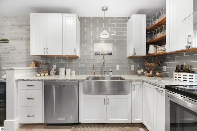 kitchen with a sink, open shelves, white cabinetry, and stainless steel appliances